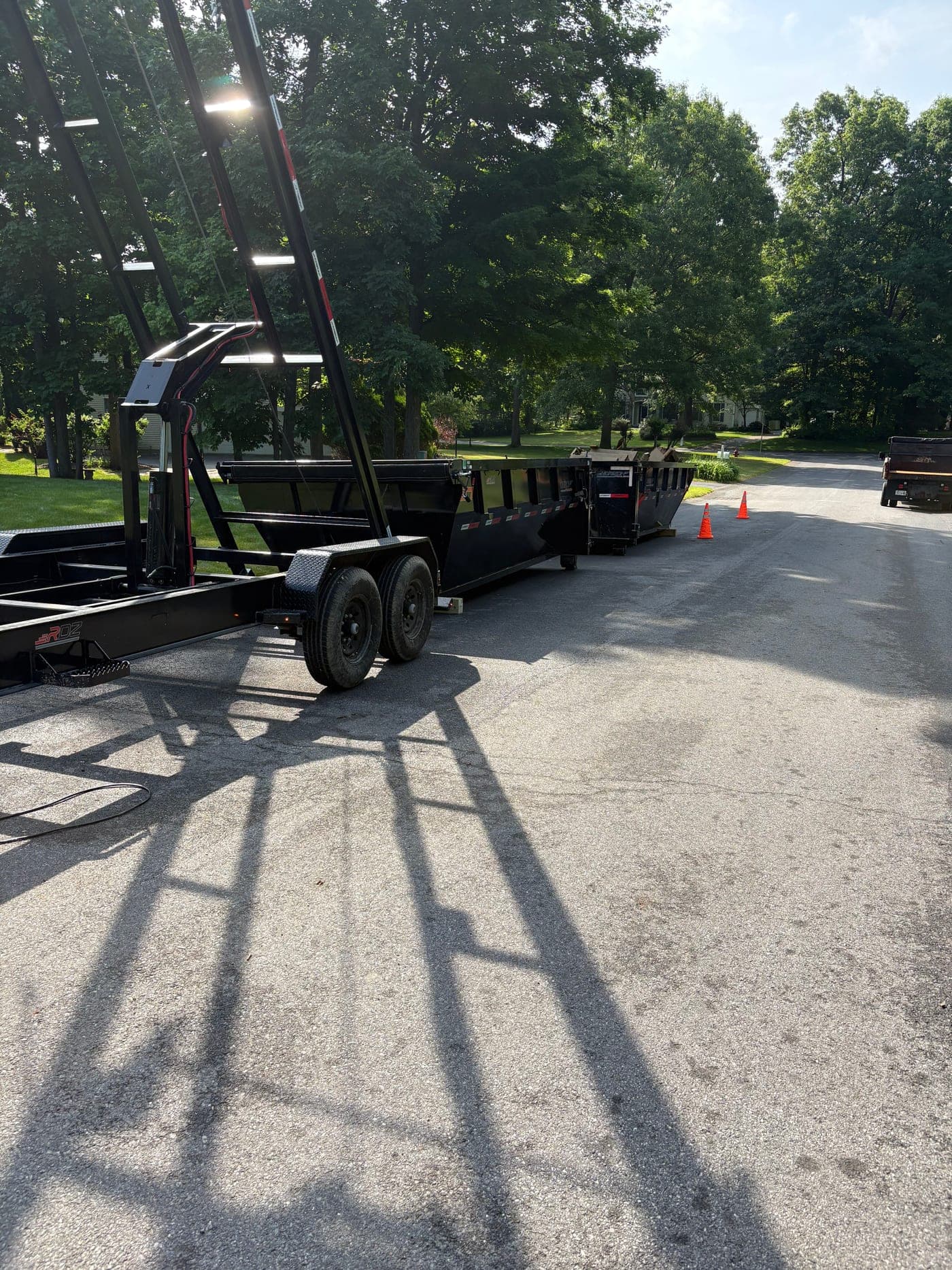 Toss Boss dumpster trailer staged for a residential driveway delivery